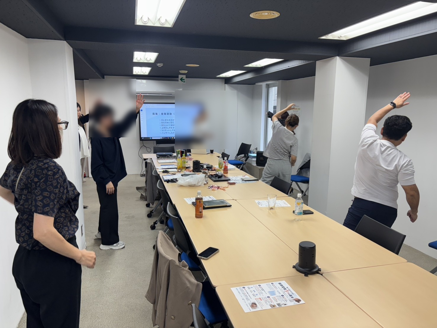オフィスでもできる簡単なストレッチを実践する社員の皆様（顔にぼかし加工済み）
